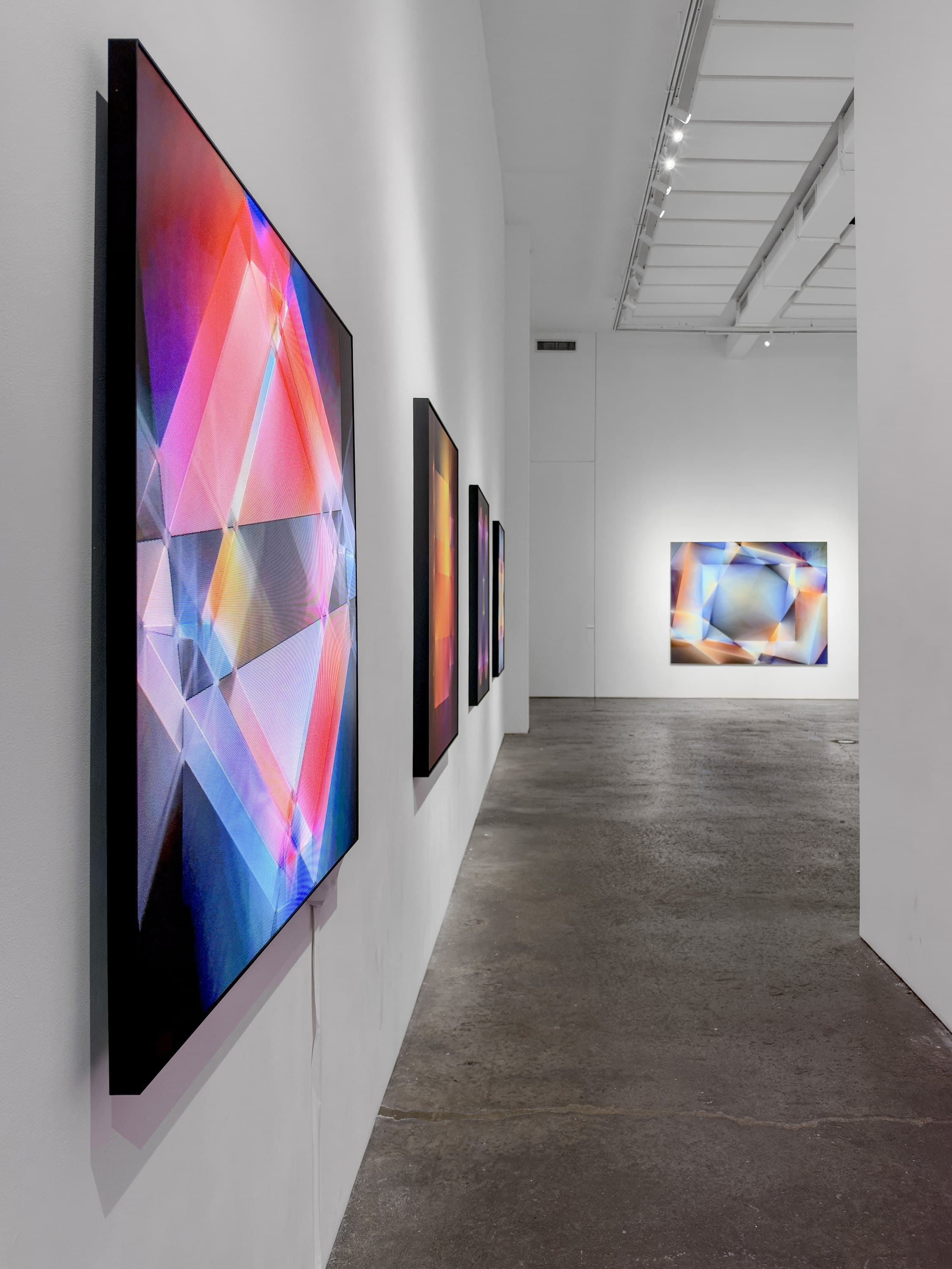 One of the Chromatic Geometries animations on its screen, seen along the gallery wall, Lightfields #1 beyond.